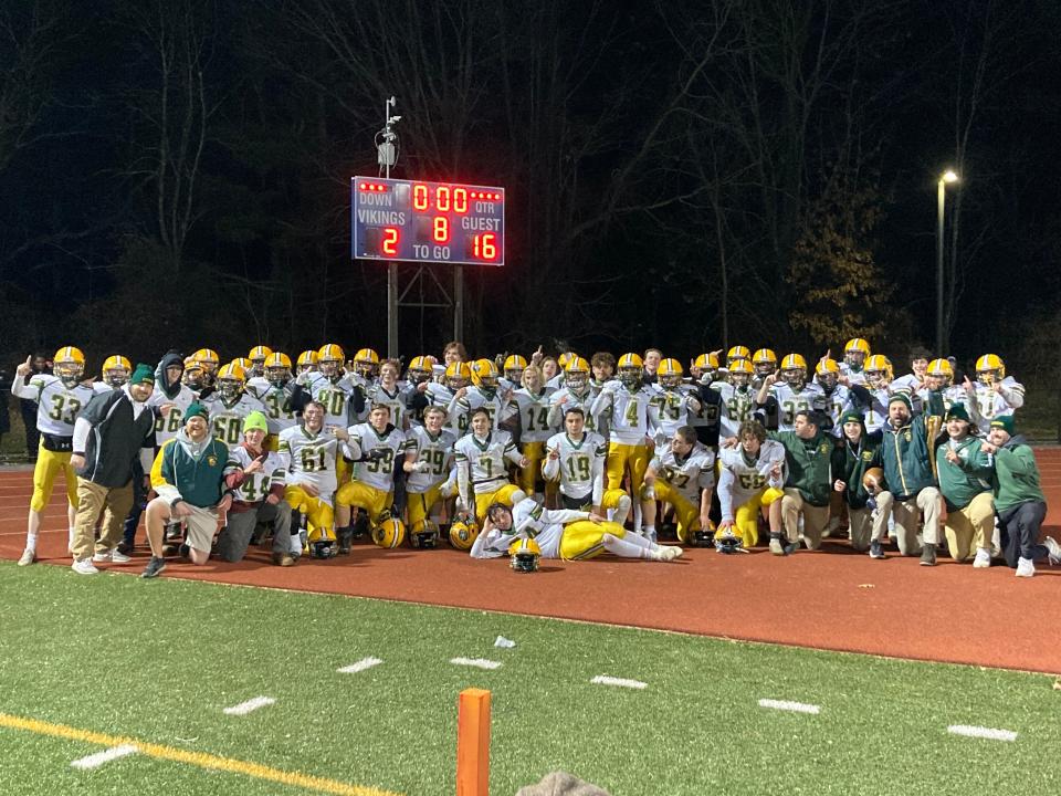 Members of the South Shore Tech football team pose in front of the scoreboard at Nashoba Valley Tech after winning the small-school state voke championship on Thursday, Dec. 1, 2022.
