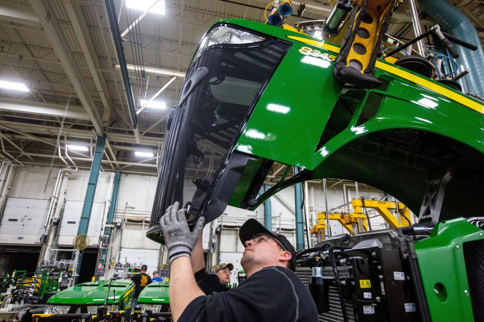Workers assemble a tractor at John Deere's Waterloo assembly plant.