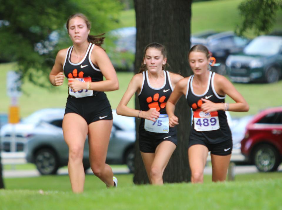 Brighton's (from left) Carrigan Eberly, Lydia LaMarra and Elle Bissett race during a cross country meet against Northville and Canton Tuesday, Sept. 12, 2023 at Cass Benton Park in Northville.