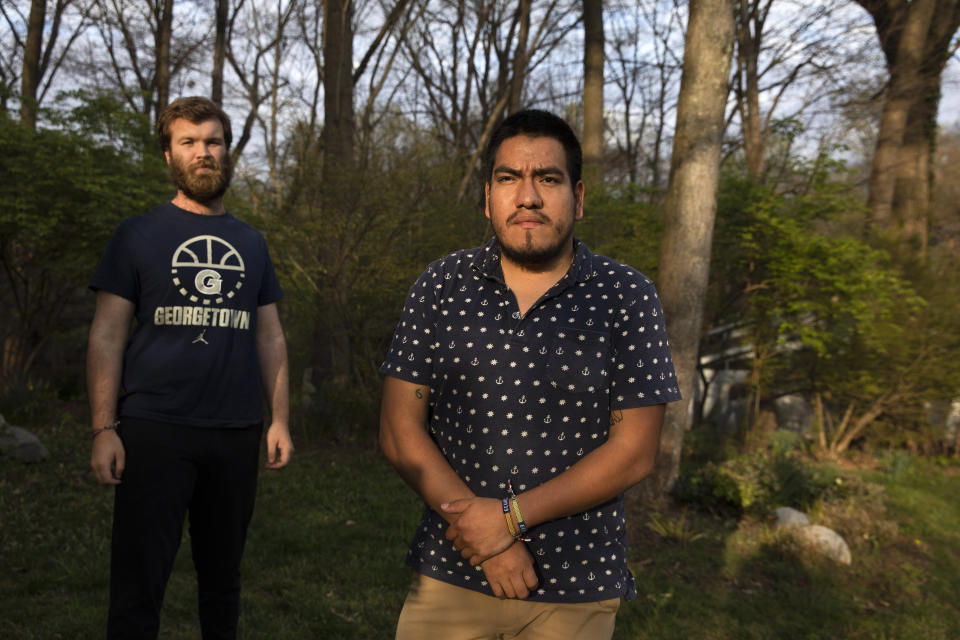 Jack Cashmere, 22, left, and Jakob Leichtman, 23, who were serving together in the Peace Corps in Ecuador for two months and were awaiting their first placements when the Peace Corps evacuated them due to coronavirus concerns, pose for a portrait outside of Cashmere's parents home in Bethesda, Md., Wednesday April 1, 2020, where the two are finishing their quarantine period together. Leichtman preferred to quarantine with Cashmere rather than put his father who is 72 at risk. (AP Photo/Jacquelyn Martin)