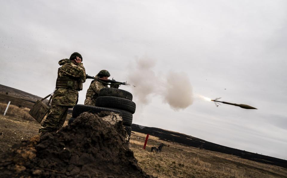Ukrainian servicemen fire an RPG rocket launcher during training