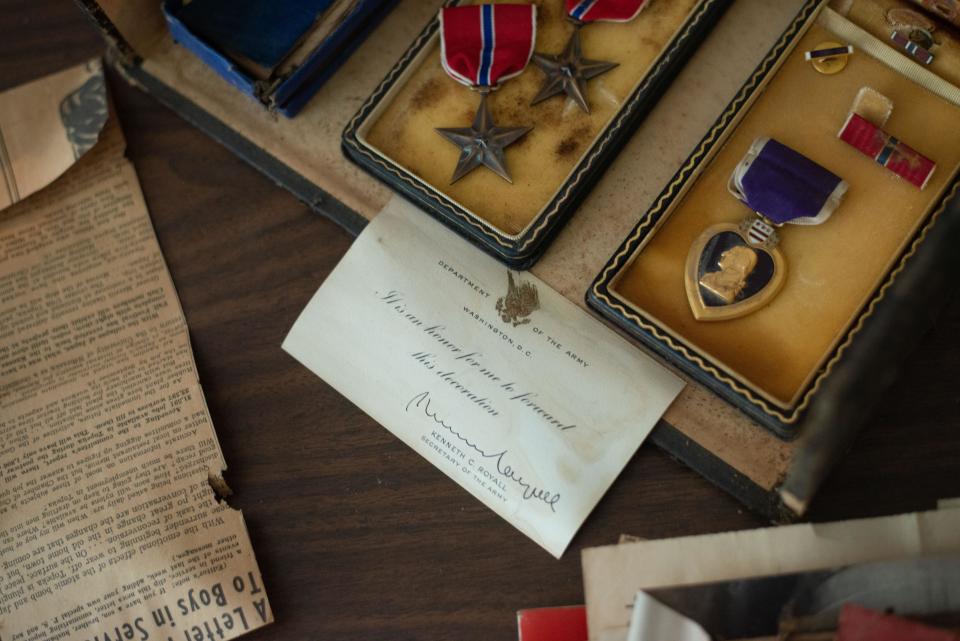 A Purple Heart, two bronze stars and other artifacts belonging to veteran Crosby "Bing" Powell were found in the garage loft of Mikell Burr's home over the Labor Day weekend. She returned those items to him Friday at his apartment in Topeka, Kansas.