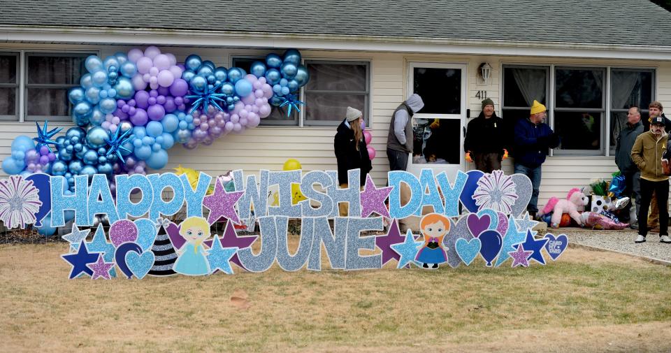 Family and friends watch as the Make a Wish parade passes by the family home, as well as  June Peden-Stade from her screen door window Saturday Dec. 17, 2022.