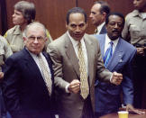 <p>O.J. Simpson, center, with defense attorneys F. Lee Bailey, left, and Johnnie Cochran after Simpson was found not guilty of murdering his ex-wife Nicole Brown Simpson and her friend Ron Goldman. (Photo: Myung J. Chun/AP) </p>