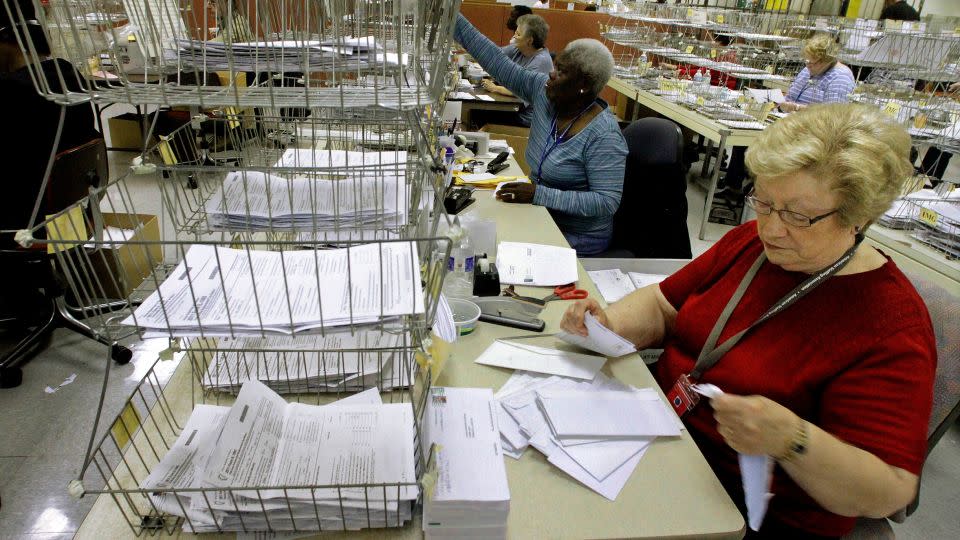 In this April 2012 photo, Illinois Department of Revenue office associate Arline Williams processes 2011 income tax forms in the Document Control and Deposit Division in Springfield, Illinois. - Seth Perlman/AP/File