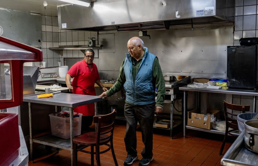 ANAHEIM, CA - MAY 3, 2023: Owner Samuel Solis talks with one of his chefs in the kitchen of his family owned restaurant Taco Boy which is one of Orange County's first taquerias on May 3, 2023 in Anaheim, California. The 45 year old restaurant has had a string of break-ins recently so they had to install metal bars on the front door and windows.(Gina Ferazzi / Los Angeles Times)