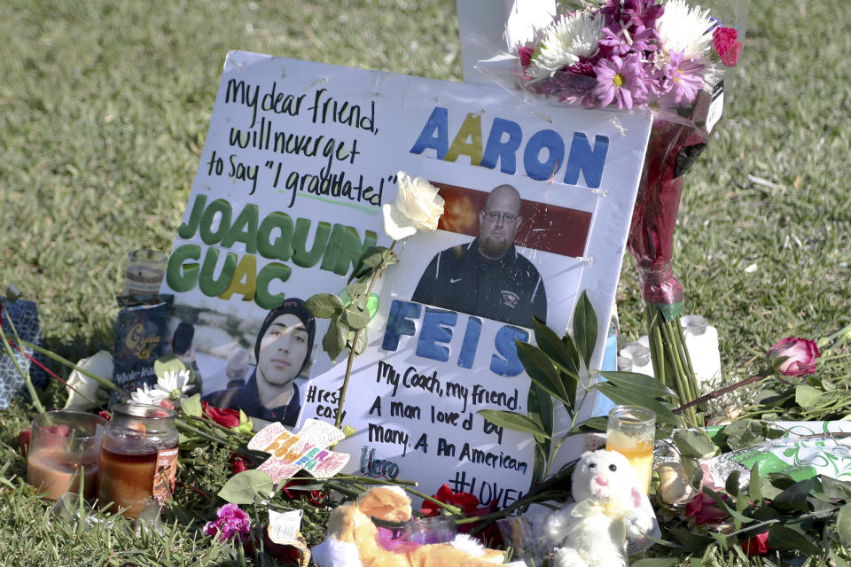 FILE - A tribute to student Joaquin Oliver and coach Aaron Feis is left at the base of a white cross at Pine Trails Park in Parkland, Fla. on Feb. 16, 2018. (Amy Beth Bennett/South Florida Sun-Sentinel via AP, File)