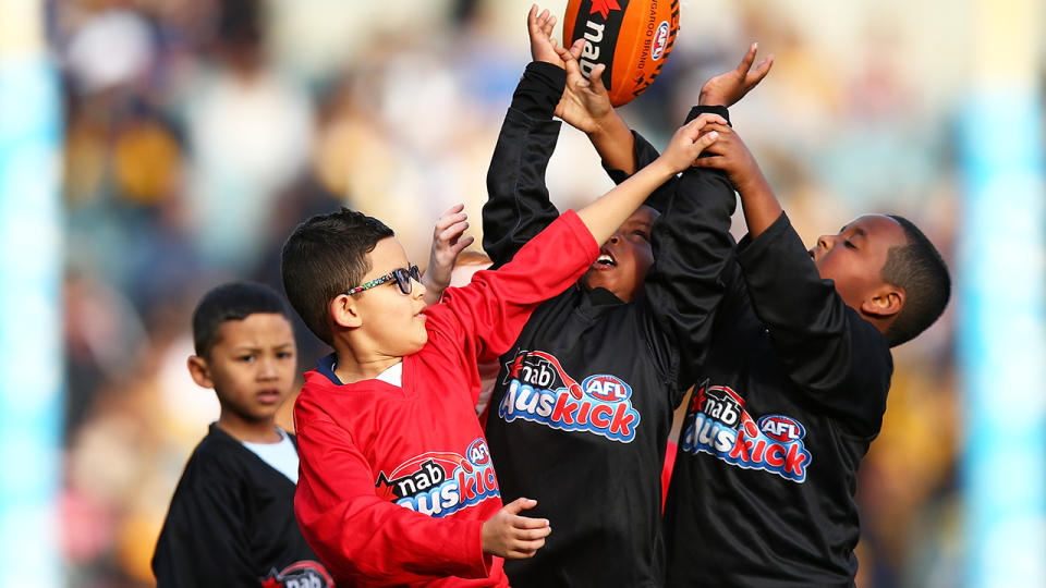 Young children play AUSKICK at the half time break of an AFL match.  (Photo by Paul Kane/Getty Images)