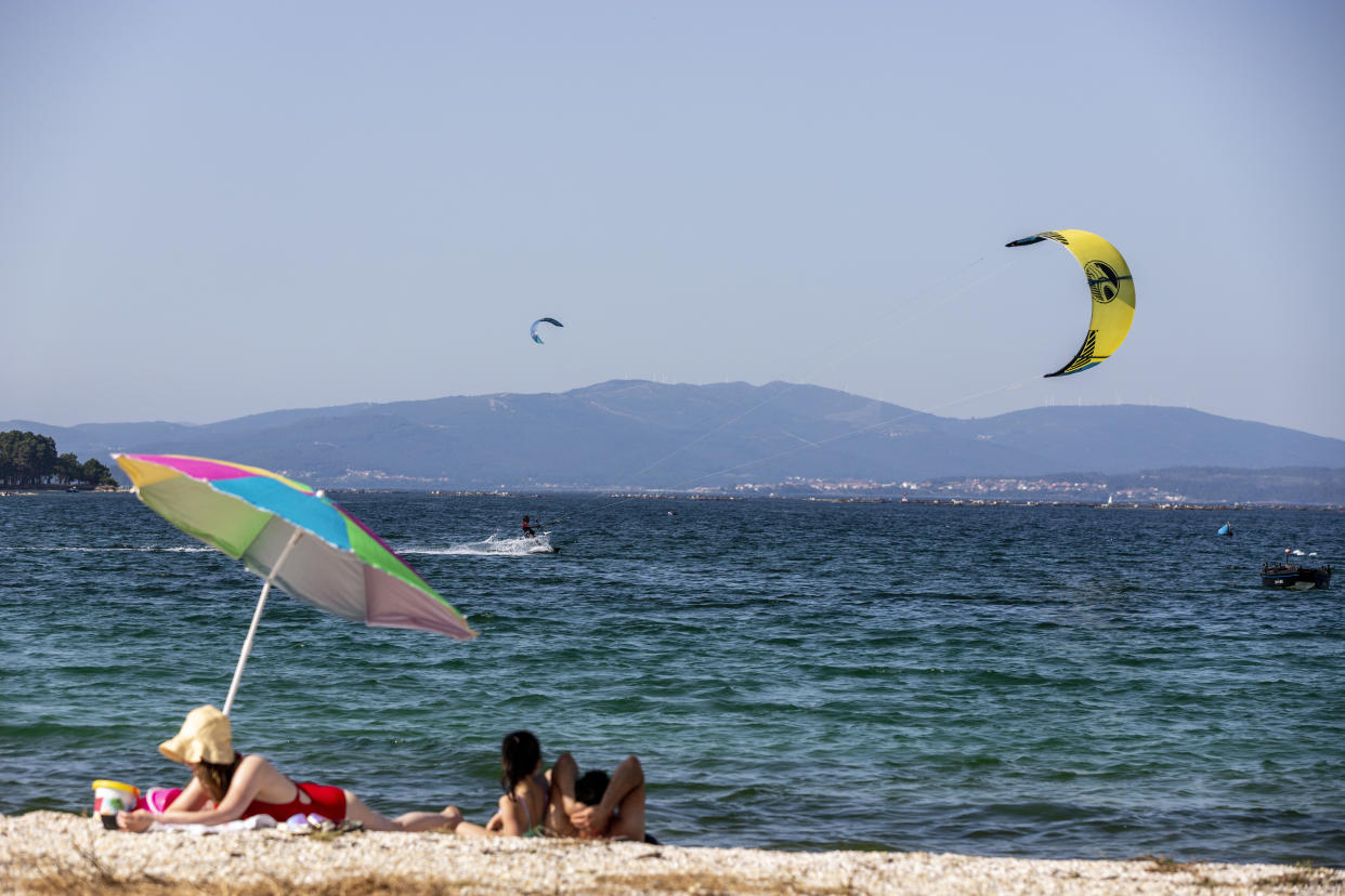 PONTEVEDRA, SPAIN - JULY 21: People practice windsurfing on the beach of O Bao on July 21, 2020 in Pontevedra, Spain. The island of Arosa, Arousa in the Galician language, has an area of approximately 7 square kilometers. It has 36 kilometers of coastline, of which 11 are beach, with fine white sand. It is one of the tourist destinations in Galicia with the most influx of visitors. (Photo by Xurxo Lobato/Getty Images)