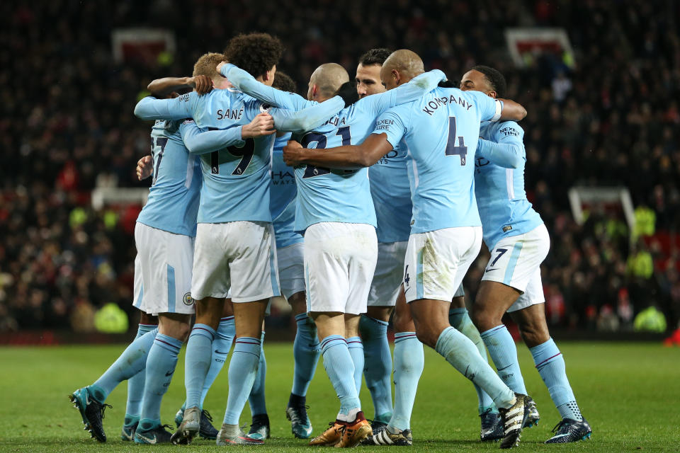 Manchester City celebrates one of its two goals against Manchester United at Old Trafford on Sunday. City won 2-1. (Getty)