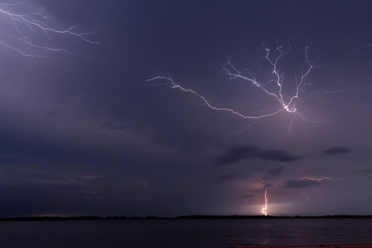 Lightning over lake at night