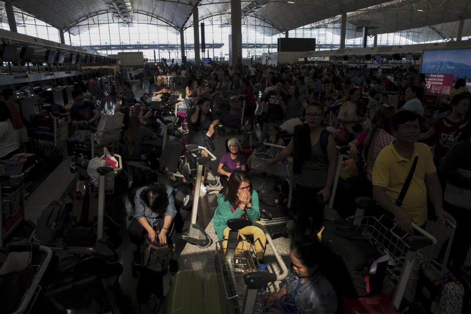 A beam of sunlight is cast on the travelers as they wait at the check-in counters in the departure hall of the Hong Kong International Airport in Hong Kong, Tuesday, Aug. 13, 2019. (Photo: Vincent Thian/AP)