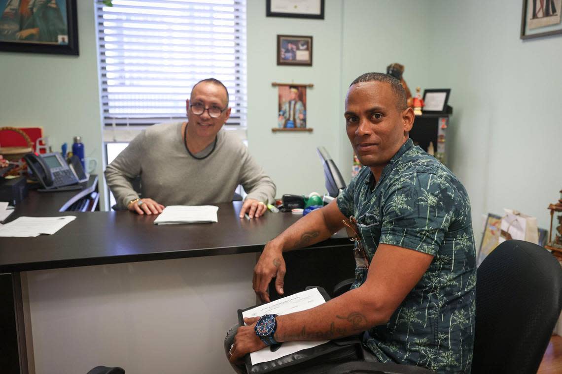 A client looking for assistance with immigration, right, meets with Emilio Garcia, at Catholic Charities on Monday, Jan. 9, 2023, in downtown Miami.