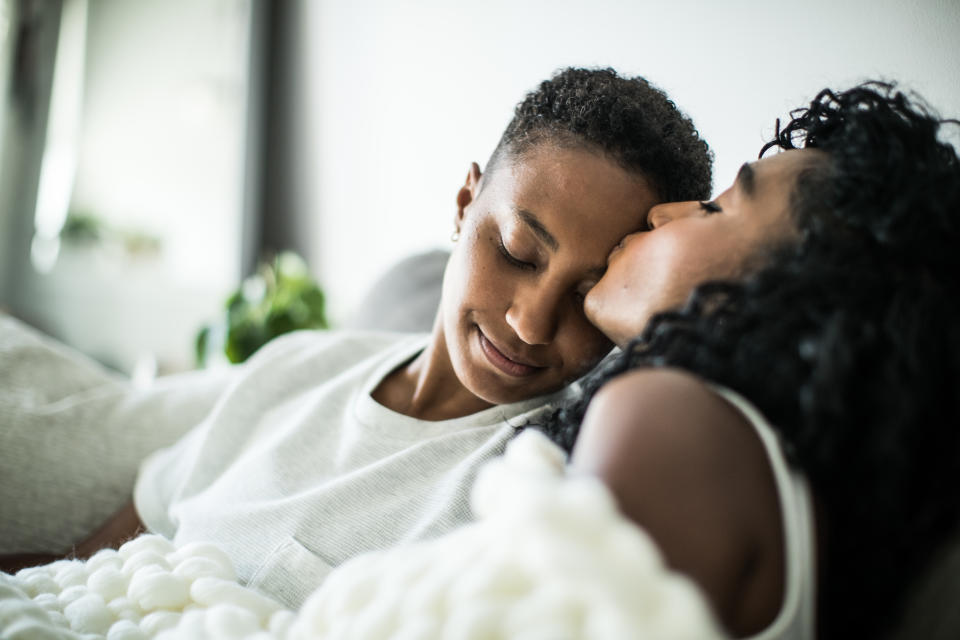 Couple kissing on sofa. (Getty Images)