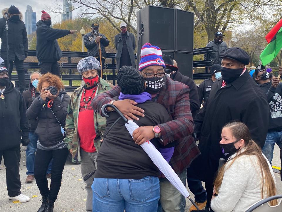 a man wearing a mask that says jacob blake on it hugs a woman