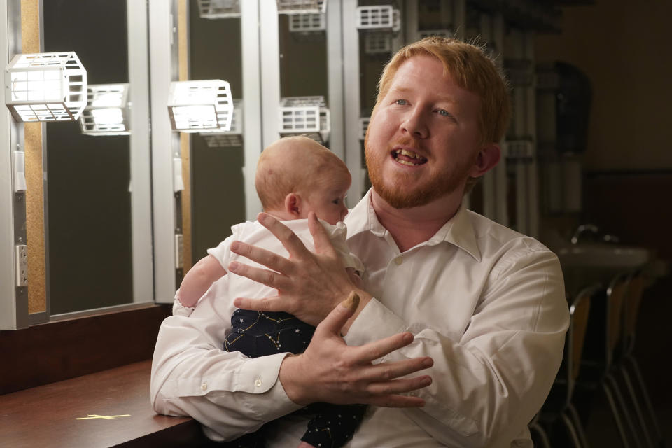 Democratic gubernatorial candidate, Del. Lee Carter, D-Manassas, gestures as he holds his baby girl, Charlotte, during an interview prior to the last primary debate in Newport News, Va., Tuesday, June 1, 2021. Carter faces four other Democrats in the primary June 8. (AP Photo/Steve Helber)