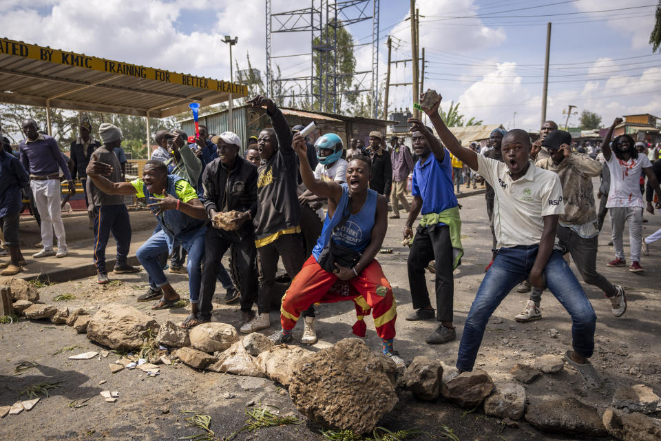 Protesters taunt police next to a barricade in the Kibera slum of Nairobi, Kenya Monday, March 20, 2023. Hundreds of opposition supporters have taken to the streets of the Kenyan capital over the result of the last election and the rising cost of living, in protests organized by the opposition demanding that the president resigns from office. (AP Photo/Ben Curtis)