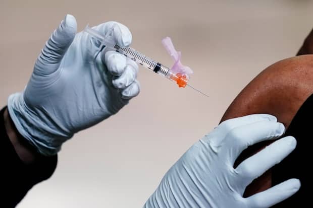 A person is vaccinated in the U.S. in this file photo. As of Wednesday, 83.9 per cent of eligible Manitobans had received one dose of a COVID-19 vaccine while 78.9 per cent had received two. (Matt Rourke/The Associated Press - image credit)