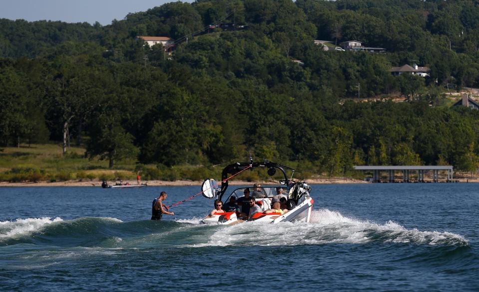 A wake surfer rides the wave created by a wake boat.