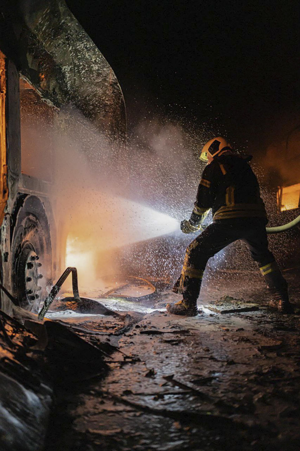 In this photo provided by the Ukrainian Emergency Situations Ministry, a firefighter tries to put out fire caused by fragments of a Russian rocket after it was shot down by air defense system during the night Russian rocket attack in Kyiv, Ukraine, early Tuesday, May 16, 2023. (Ukrainian Emergency Situations Ministry via AP)