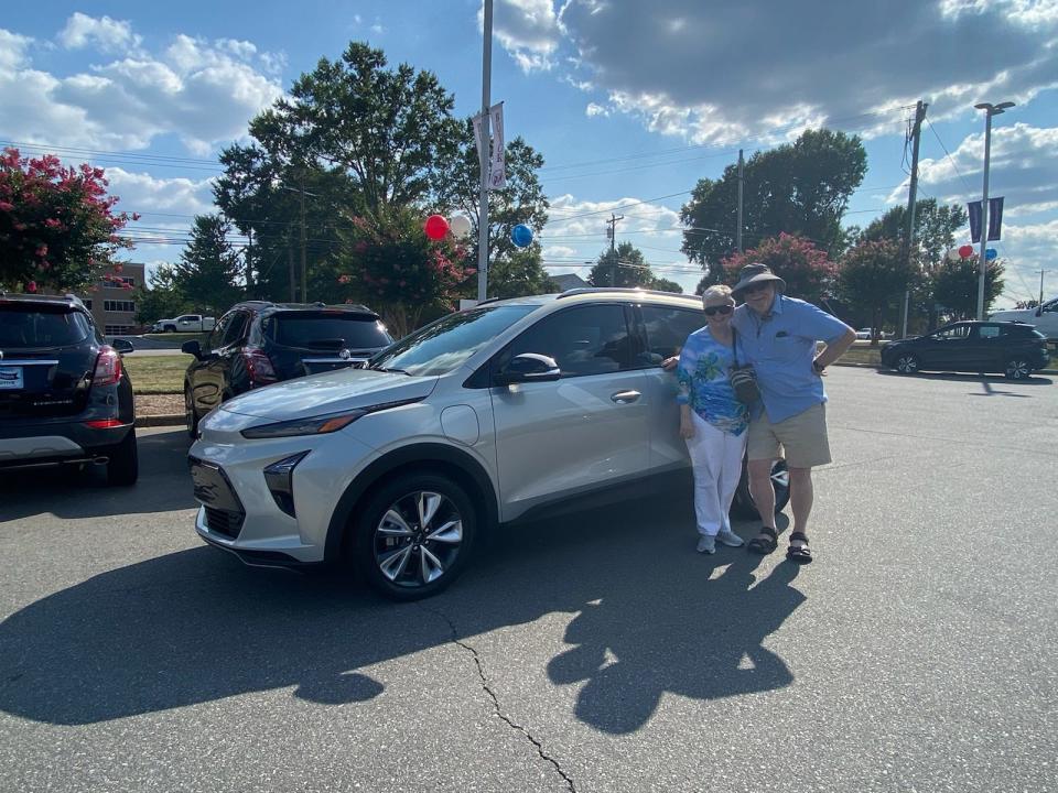 Durham Smith and Cyndie Smith stand with their new 2022 Chevy Bolt EUV on August 5, 2021 at the dealership after buying it. But 15 days later, GM recalled all model year Bolts including their new one. They want GM to buy it back.