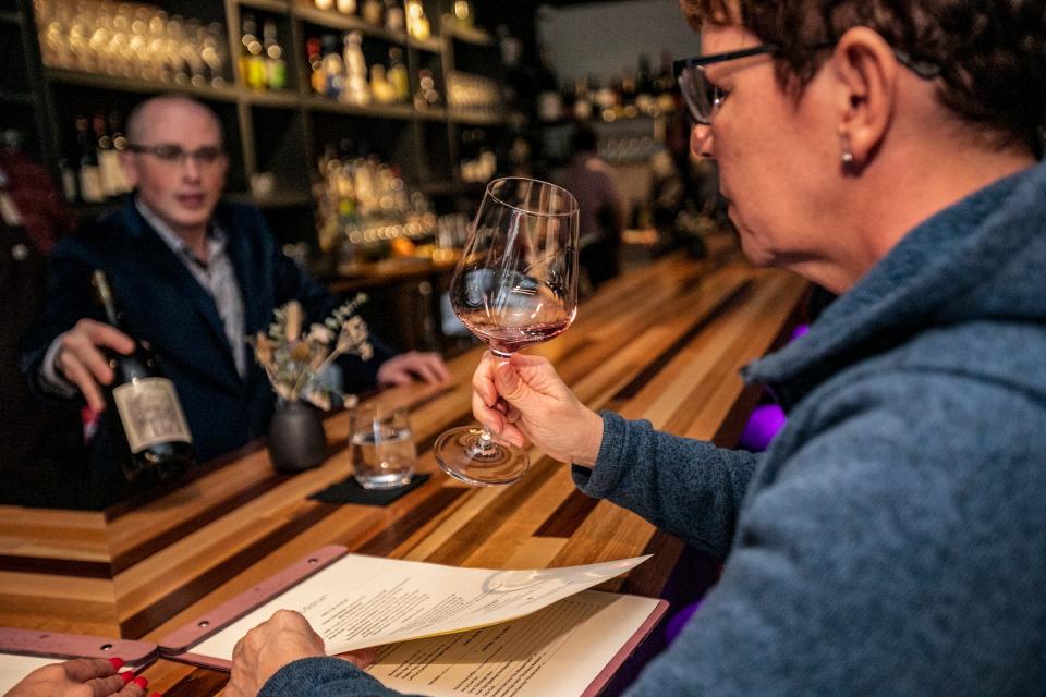 Mindy Coupples, 58, of Ferndale samples a wine offered by sommelier Sean Crenny whiile dining at Coeur.