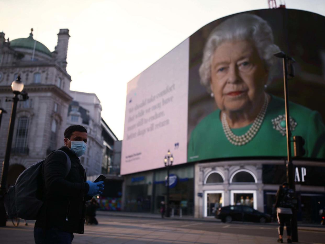 An image of Queen Elizabeth II and quotes from her coronavirus broadcast on Sunday are displayed in London: PA