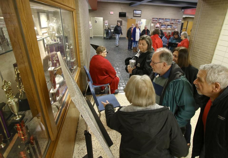 Former Alliance High School Marching Band members look over a 1961 band photo on Jan. 28 at the high school. Ed Hall Jr. / Special to The Review
