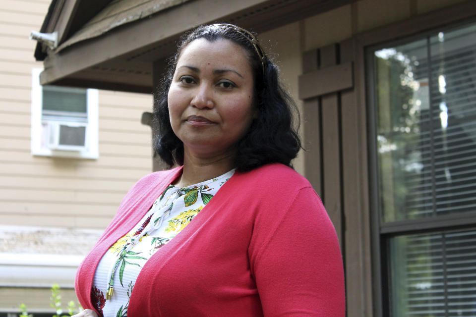 In this Thursday, June 18, 2020, photo, Honduran native Lidia Reyes poses for a photo in Durham, N.C. Reyes returned to her home in Durham after being treated at a hospital for COVID-19. She and her husband went without pay for three weeks after she lost her job at Subway during the pandemic. (AP Photo/Bryan Anderson)