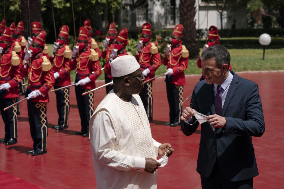 Senegal's President Macky Sall, left, welcomes Spanish Prime Minister Pedro Sanchez prior to a meeting at the presidential palace in Dakar, Senegal, Friday, April 9, 2021. Sanchez is on a mini-tour to Angola and Senegal that are key in the European country's new push to bolster ties with the neighboring continent and mitigate the migration flows that many fear could increase as a consequence of the coronavirus pandemic. (AP Photo/Leo Correa)