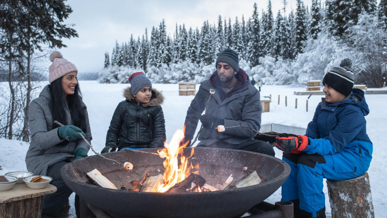  How to build a campfire in winter: family around winter fire. 
