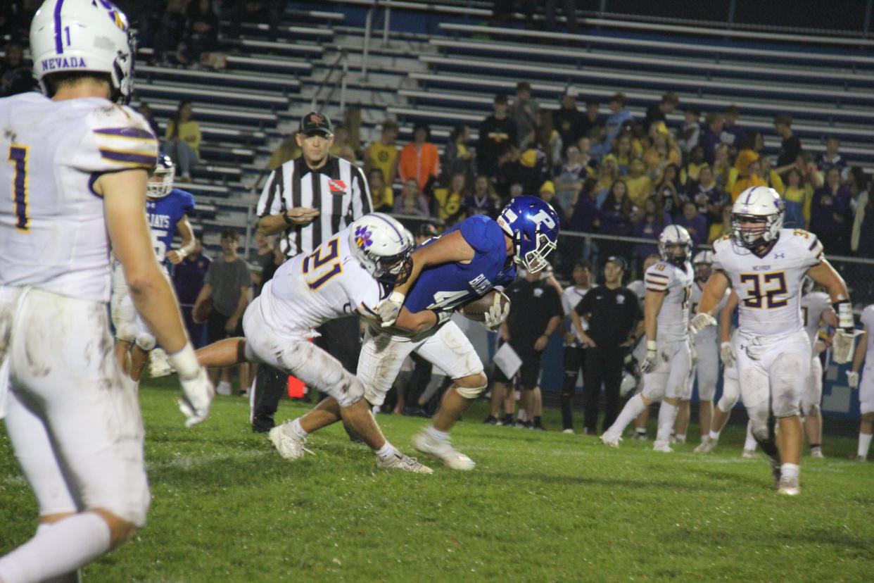 Perry's Eric Lagos battles for a few more yards against Nevada's Austin Waldera on Friday, Sept. 22, 2023, at Dewey Field in Perry.