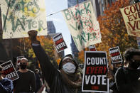 Zhanon Morales, 30, of Philadelphia, raises her fist as demonstrators call for all votes be counted during a rally outside the Pennsylvania Convention Center, Thursday, Nov. 5, 2020, in Philadelphia, as vote counting in the general election continues. (AP Photo/Rebecca Blackwell)