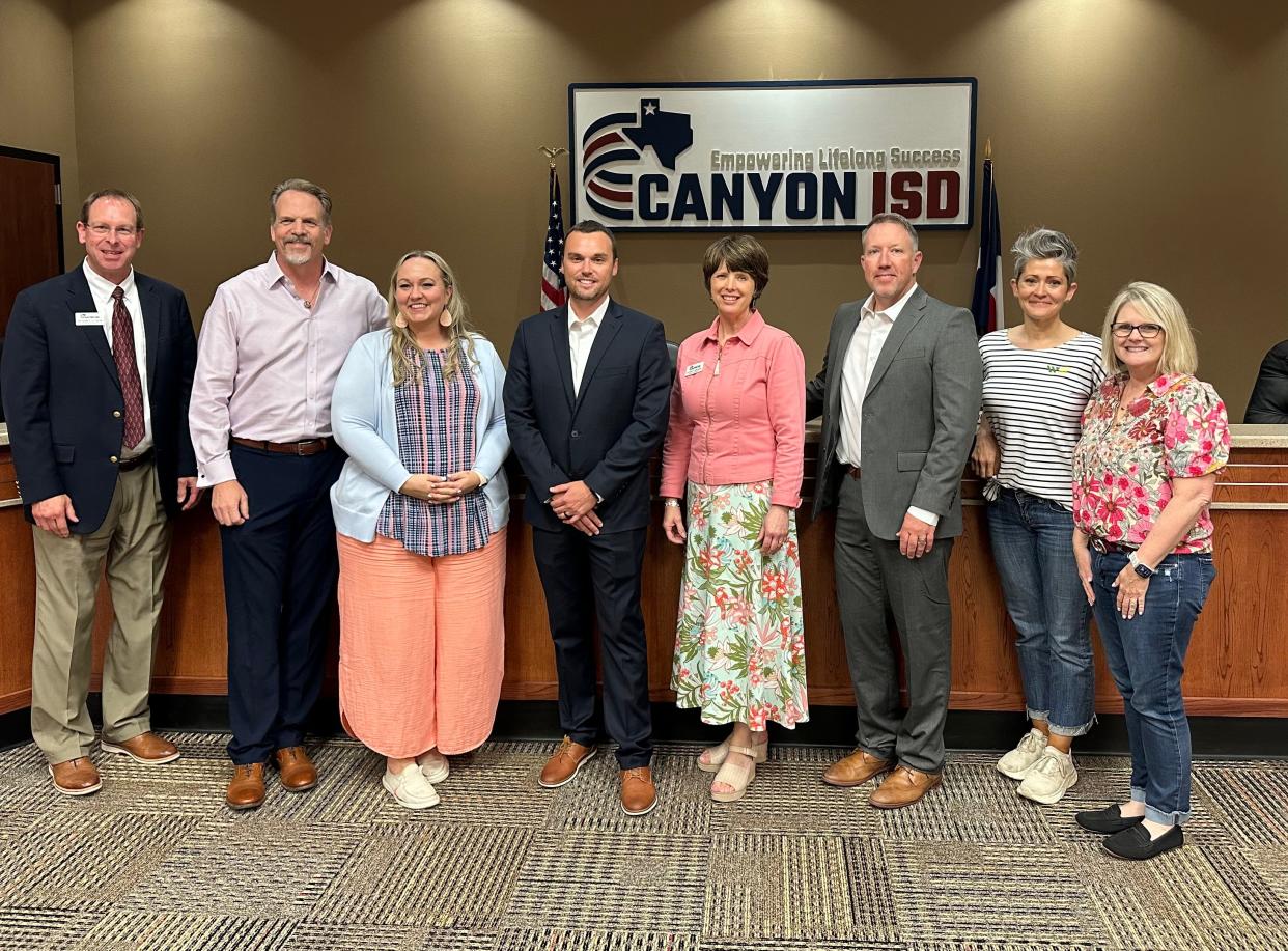 Newly appointed Canyon ISD Athletic Director John Peterson stands with Canyon ISD board members Monday at the Canyon ISD Administration Building.