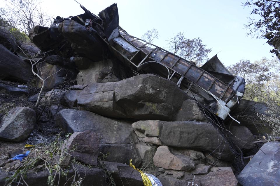 The wreckage off a bus lays in a ravine a day after it plunged off a bridge on the Mmamatlakala mountain pass between Mokopane and Marken, around 300km (190 miles) north of Johannesburg, South Africa, Friday, March 29, 2024. A bus carrying worshippers on a long-distance trip from Botswana to an Easter weekend church gathering in South Africa plunged off a bridge on a mountain pass Thursday and burst into flames as it hit the rocky ground below, killing at least 45 people, authorities said. The only survivor was an 8-year-old child who was receiving medical attention for serious injuries. (AP Photo/Themba Hadebe)