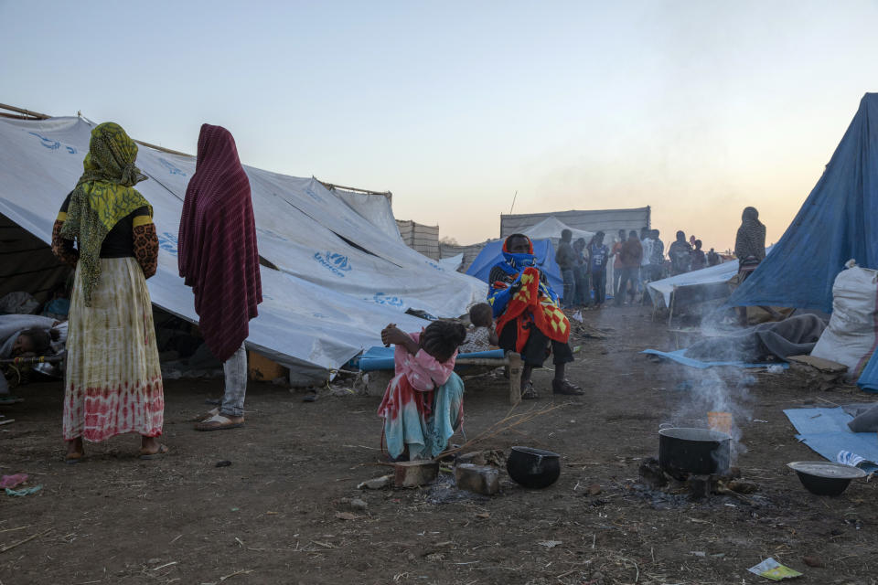 Tigray refugees who fled the conflict in the Ethiopia's Tigray sit up after waking up early morning at Hamdeyat Transition Center near the Sudan-Ethiopia border, eastern Sudan, Thursday, Dec. 3, 2020. Ethiopian forces on Thursday blocked people from the country's embattled Tigray region from crossing into Sudan at the busiest crossing point for refugees, Sudanese forces said.(AP Photo/Nariman El-Mofty)