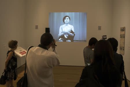 Guests interact with a video of the Yoko Ono exhibit "Cut Piece" at the Museum of Modern Art exhibition dedicated exclusively to Ono's work, titled "Yoko Ono: One Woman Show, 1960-1971", in New York May 12, 2015. REUTERS/Lucas Jackson