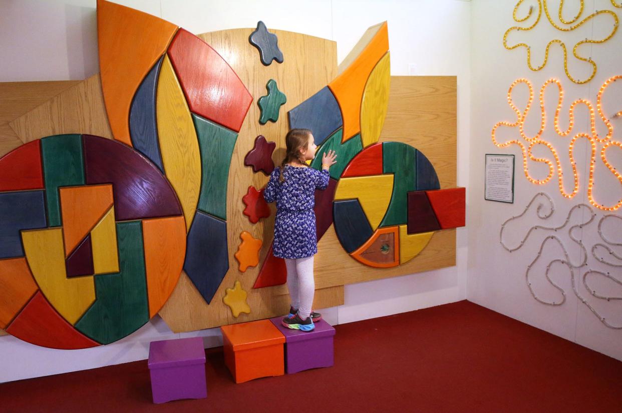 Making music by pushing panels and seeing a light display to the right is one of the many activities offered at the Children's Museum of New Hampshire in Dover.