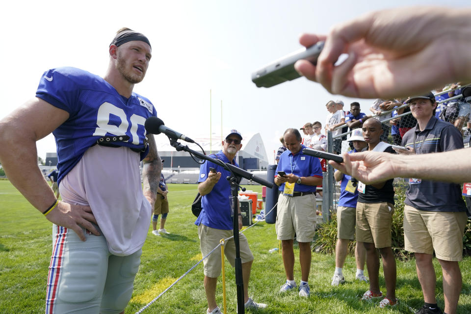 New York Giants tight end Kyle Rudolph, left, faces reporters following a joint NFL football practice with the New England Patriots, Wednesday, Aug. 25, 2021, in Foxborough, Mass. (AP Photo/Steven Senne)