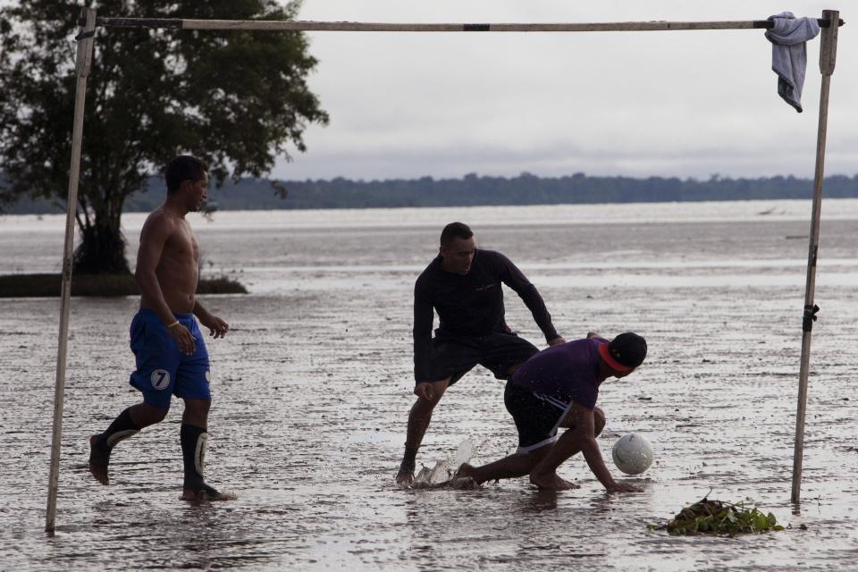 Youths play "futelama" or mud soccer, on tidal flats near the mouth of the Amazon river in Macapa, Amapa state, May 11, 2014. Brazilians from this region play anything from pick up games to organized tournaments of futelama throughout the year. The 2014 World Cup will be held in Brazil starting on June 12. Picture taken May 11, 2014. REUTERS/Paulo Santos (BRAZIL - Tags: SPORT SOCCER WORLD CUP ENVIRONMENT)