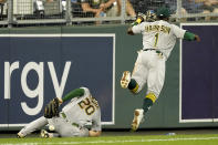 Oakland Athletics third baseman Josh Harrison (1) and left fielder Mark Canha (20) can't catch a fly foul ball hit by Kansas City Royals' Whit Merrifield during the fifth inning of a baseball game Wednesday, Sept. 15, 2021, in Kansas City, Mo. (AP Photo/Charlie Riedel)