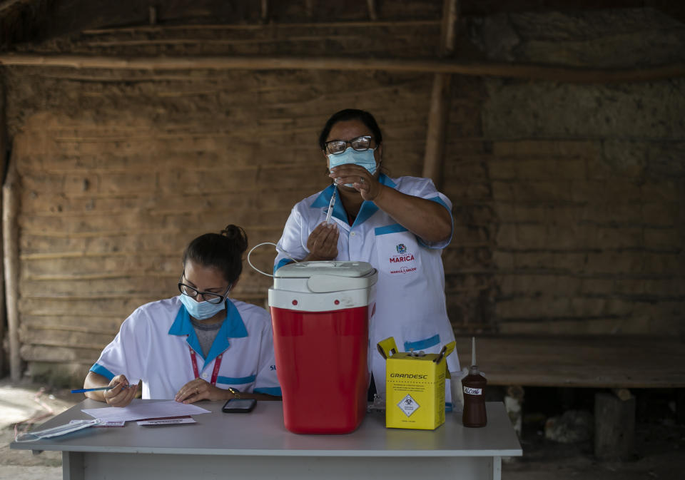 A healthcare worker prepares a dose of China's Sinovac COVID-19 vaccine at the Mata Verde Bonita village in Marica, Rio de Janeiro state, Brazil, Thursday, Feb. 25, 2021, as part of a mass immunization program aimed at inoculating all of Rio’s 16 million residents by the end of the year. (AP Photo/Bruna Prado)