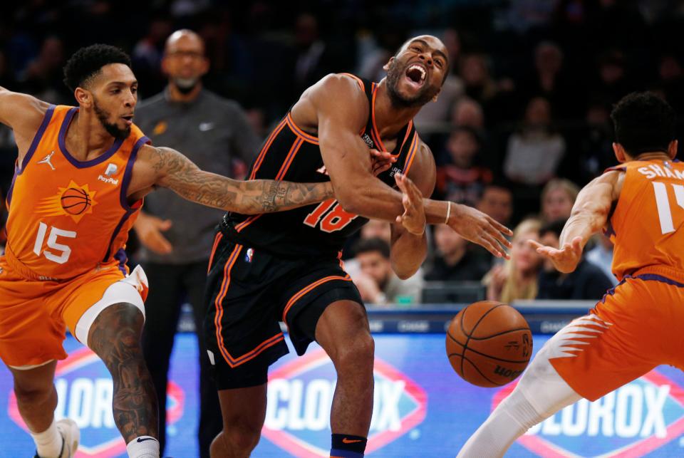 New York Knicks' Alec Burks (18) drives between Phoenix Suns' Cameron Payne (15) and Landry Shamet (14) during the first half of an NBA basketball game Friday, Nov. 26, 2021, in New York. AP Photo/John Munson)