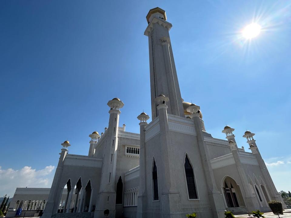 a mosque with white walls and gold domes