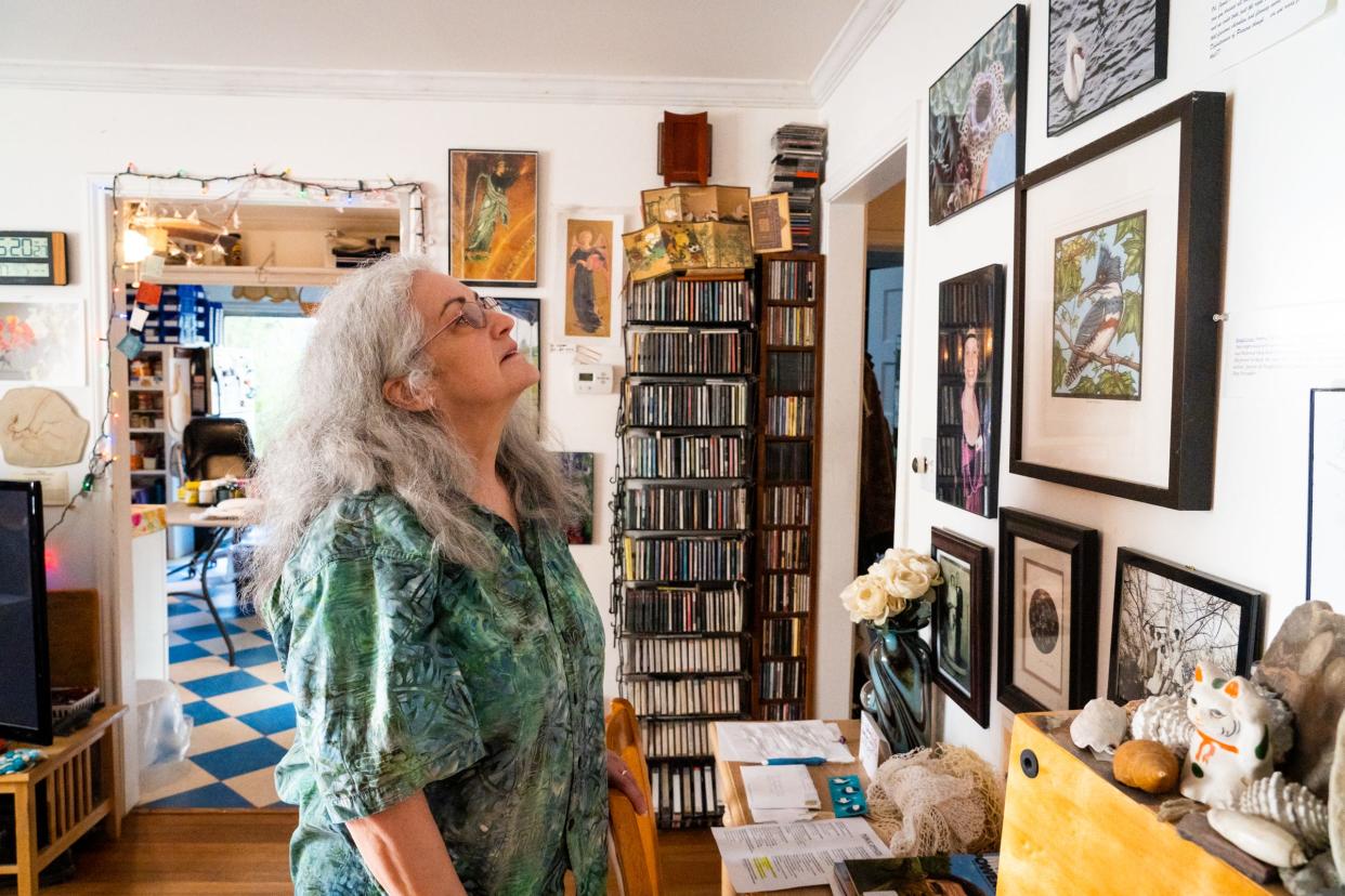 Jimmy Hendricks' sister, Ruth Hendricks Brough, looks at photos and other mementos displayed on the walls of her brother's home in Austin. Hendricks, who died this month in Arches National Park while on a trip to spread his father's ashes, loved photography, gardening, fossils and had many collections.