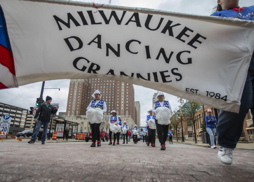 A banner for the Milwaukee Dancing Grannies flutters in the wind as the Grannies march in a Veterans’ Day parade in Milwaukee on Saturday, Nov. 5, 2022. The group dances to a number of songs, including “We Are Family,” “Pretty Woman” and “Old Time Rock and Roll.” They also have special routines and songs for holidays. (AP Photo/Kenny Yoo)