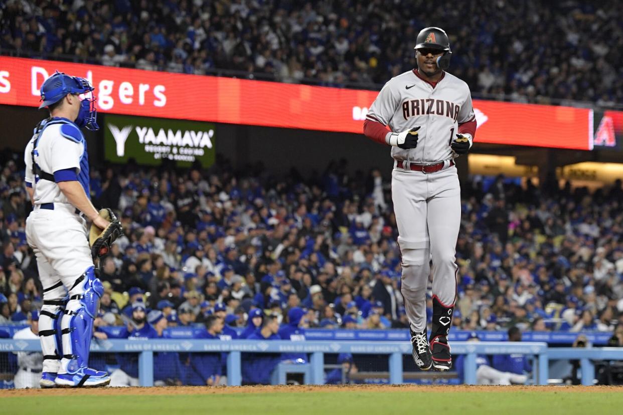 Arizona's Kyle Lewis crosses home plate in front of Dodgers catcher Will Smith.