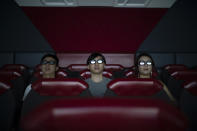 In this Oct. 11, 2019 photo, people watch a 3D movie part of the Iron Man Experience at Hong Kong Disneyland in Hong Kong. The body-blow of months of political protests on Hong Kong’s tourism is verging on catastrophic for one of the world’s great destinations. Geared up to receive 65 million travelers a year, the city’s hotels, retailers, restaurants and other travel-oriented industries are suffering. But some intrepid visitors came specifically to see the protests and are reveling in deep discounts and unusually short lines at tourist hotspots.(AP Photo/Felipe Dana)