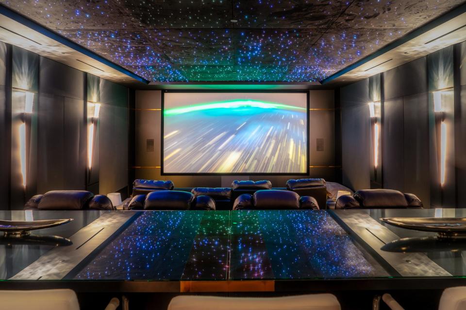 A home theater inside the Star Resort, with several chairs facing a projector screen.