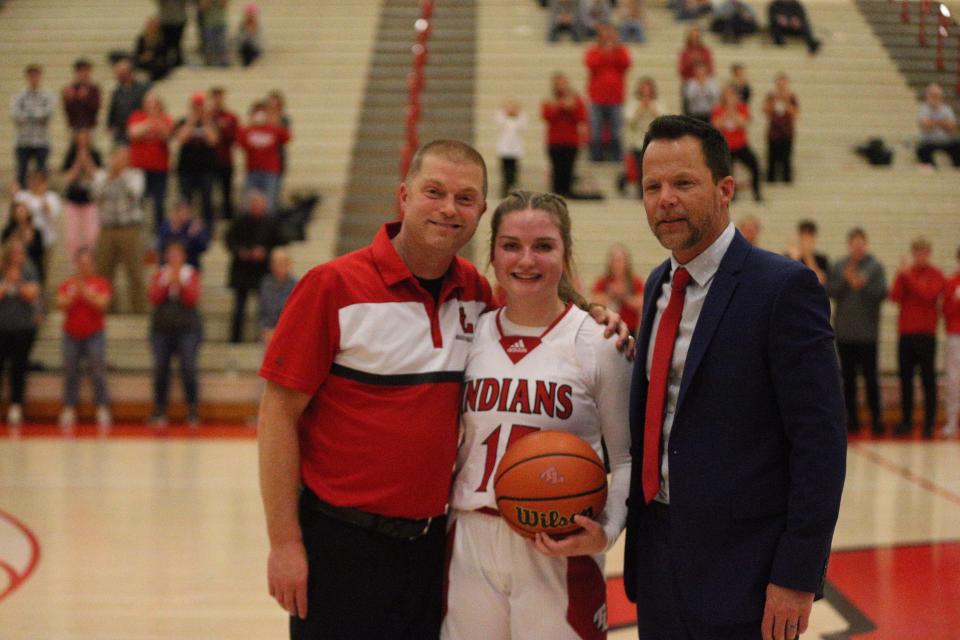 Twin Lakes senior Olivia Nickerson (center) basks in the moment of becoming the Indiana high school 3-point career leader with her father/coach Troy Nickerson (left) and Twin Lakes head coach Brad Bowsman on Wednesday, Dec. 27, 2023.